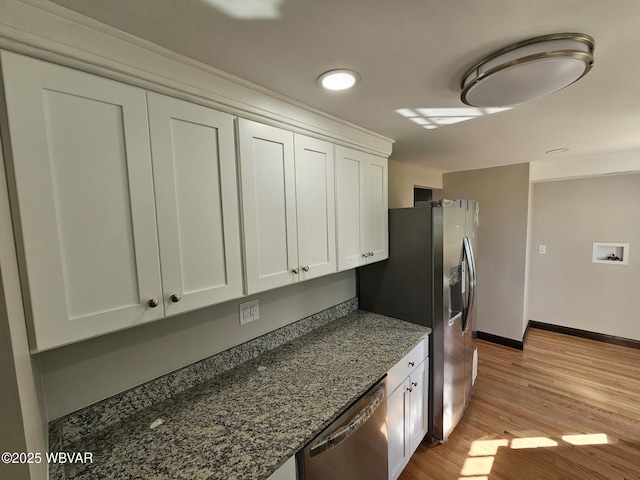 353 Louise Ave, Montgomery, PA 17752 - kitchen with light wood-type flooring, dark stone counters, baseboards, appliances with stainless steel finishes, and white cabinetry