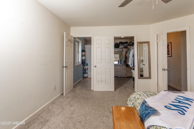 carpeted bedroom featuring ceiling fan, a closet, and a spacious closet