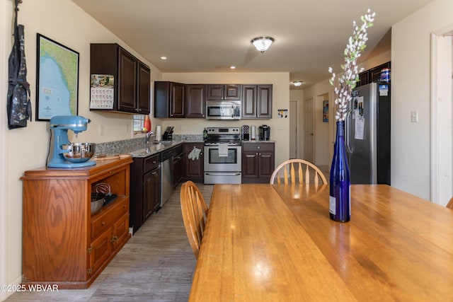 kitchen with dark brown cabinets, light hardwood / wood-style floors, sink, and stainless steel appliances