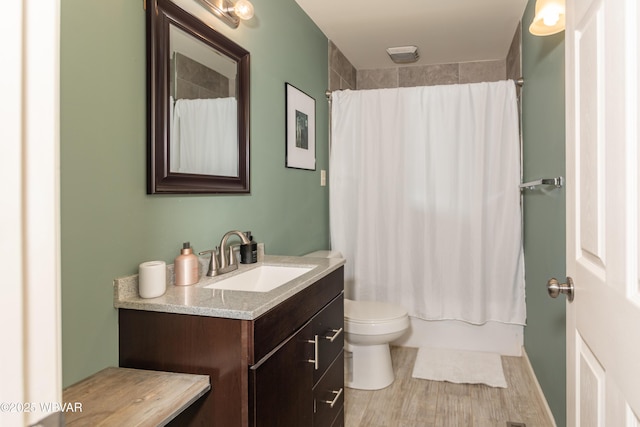 full bathroom featuring shower / bath combo, vanity, hardwood / wood-style flooring, and toilet