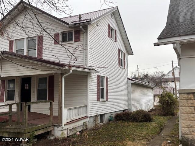 view of side of property featuring covered porch