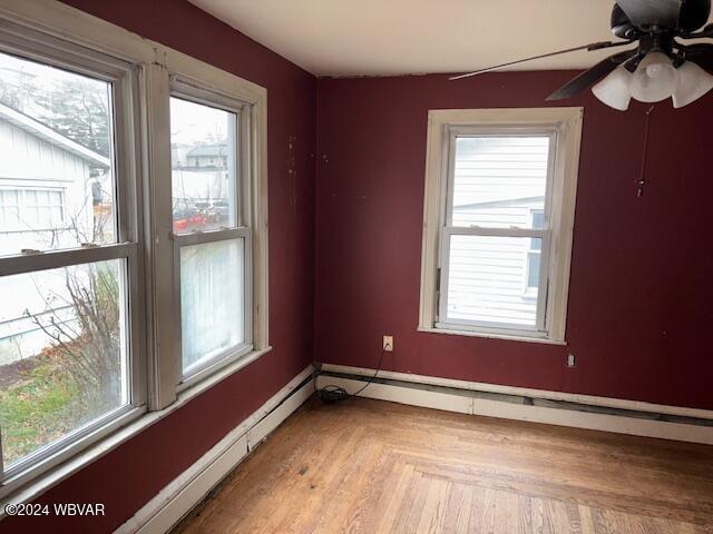 empty room with light parquet flooring, ceiling fan, and a healthy amount of sunlight