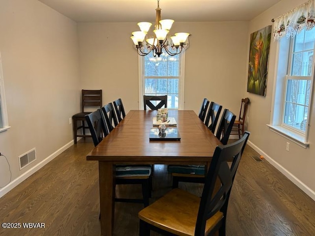 dining area featuring dark hardwood / wood-style flooring, plenty of natural light, and a chandelier