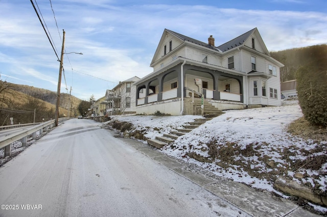 view of snowy exterior with covered porch