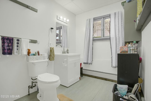 bathroom with vanity, a baseboard heating unit, and toilet