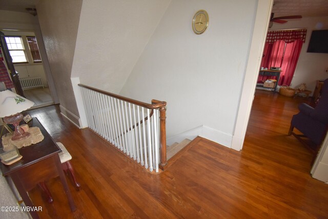 45 W Bald Eagle St, Lock Haven, PA 17745 - stairs featuring wood finished floors, radiator heating unit, a ceiling fan, and baseboards