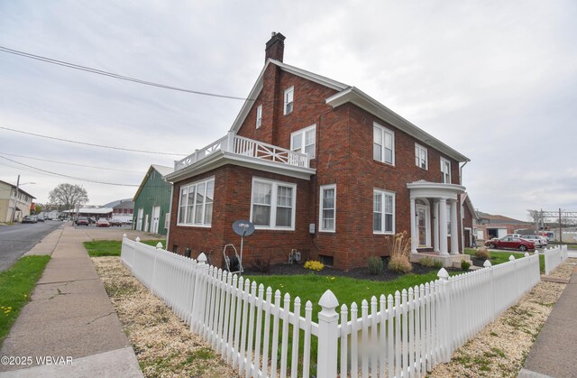 45 W Bald Eagle St, Lock Haven, PA 17745 - view of home's exterior with a balcony, brick siding, and a chimney