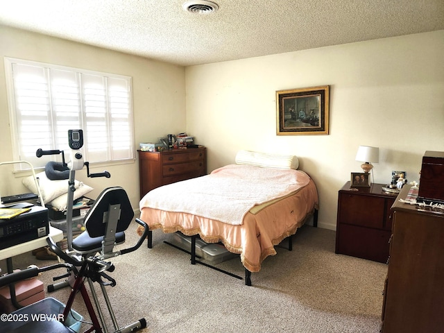 bedroom with carpet floors, an office area, and a textured ceiling
