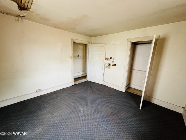 interior space featuring a closet and dark carpet