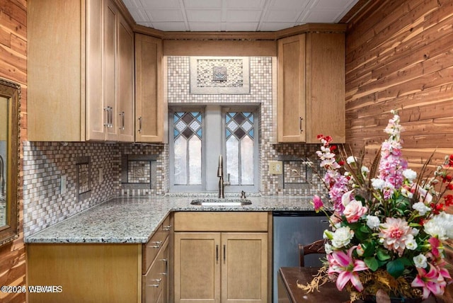 kitchen with backsplash, a drop ceiling, light stone counters, and sink