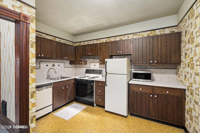 kitchen with dark brown cabinets, white appliances, sink, and tasteful backsplash