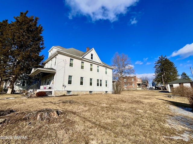 view of home's exterior with covered porch and a chimney