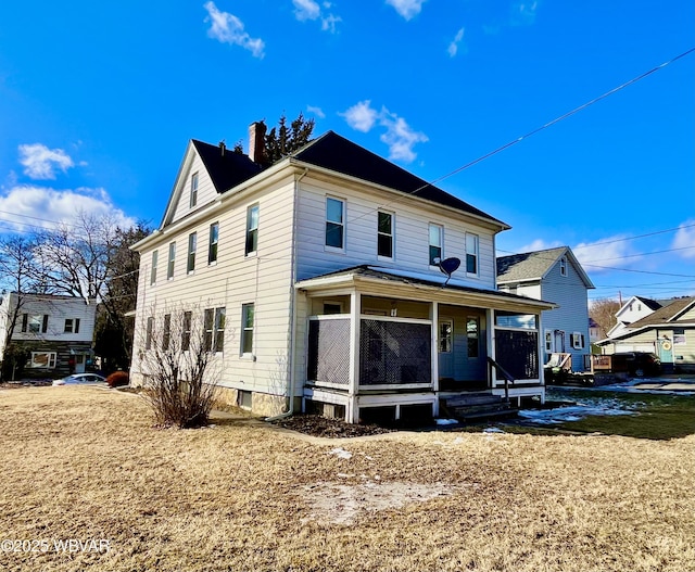 back of property featuring a porch and a chimney