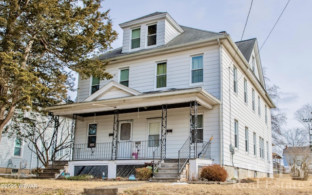 american foursquare style home featuring a shingled roof and covered porch