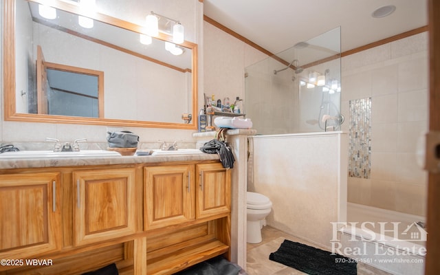 bathroom with toilet, ornamental molding, tiled shower, and vanity