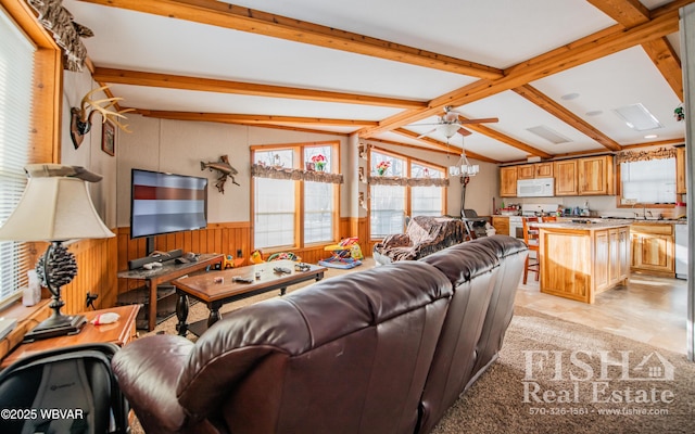 living room with ceiling fan and lofted ceiling with beams