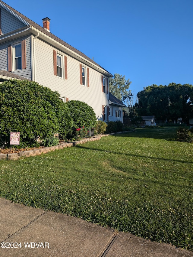 view of side of home with a yard