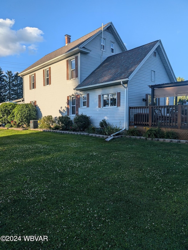 back of house with a lawn, a wooden deck, and central air condition unit