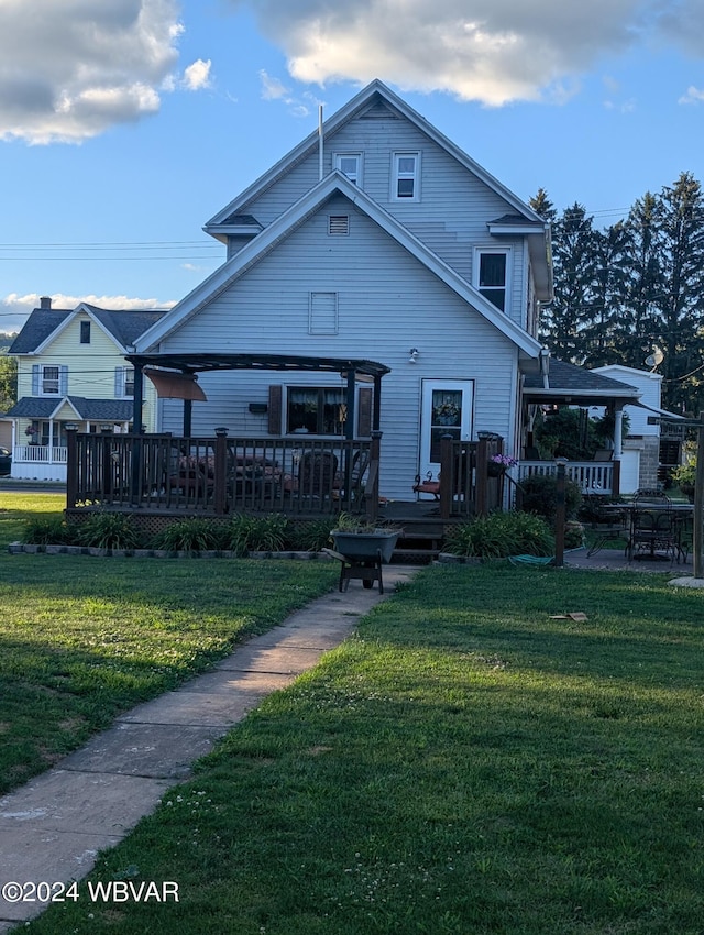 rear view of house with a wooden deck and a lawn