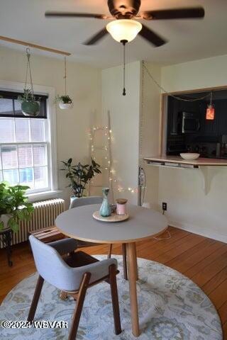 dining room featuring ceiling fan, radiator heating unit, and hardwood / wood-style floors