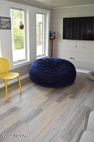 sitting room with wood-type flooring and wood walls