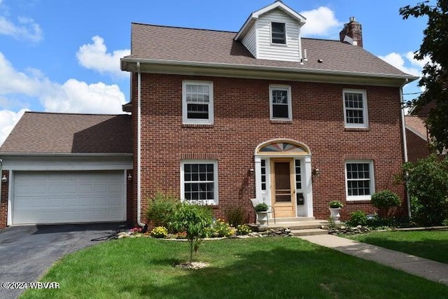 colonial inspired home with a garage and a front yard