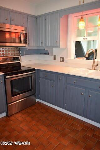 kitchen with pendant lighting, backsplash, sink, stainless steel appliances, and extractor fan