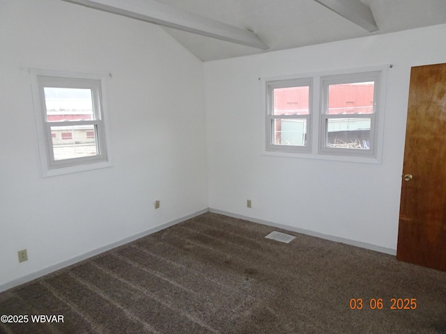 unfurnished room with lofted ceiling with beams, dark carpet, a wealth of natural light, and baseboards