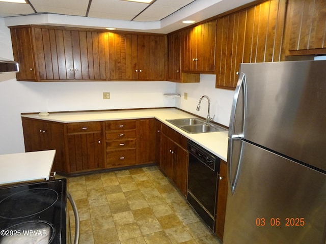 kitchen featuring black appliances, a drop ceiling, light countertops, and a sink