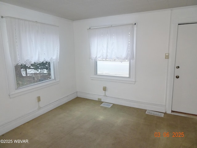 unfurnished room featuring carpet flooring, visible vents, and baseboards