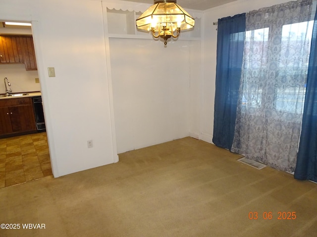 spare room with light colored carpet, a sink, visible vents, and an inviting chandelier