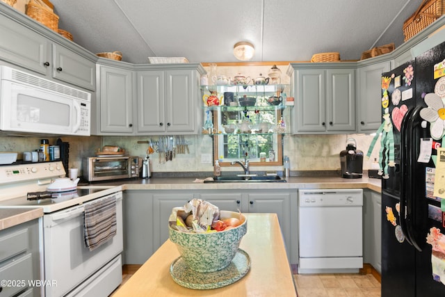 394 Rte 973, Cogan Station, PA 17728 - kitchen with white appliances, gray cabinetry, a sink, vaulted ceiling, and a textured ceiling