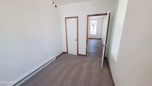 carpeted empty room with a baseboard heating unit