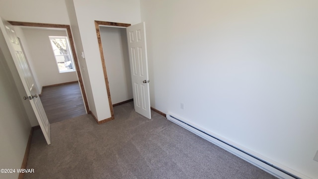 unfurnished bedroom featuring carpet and a baseboard heating unit