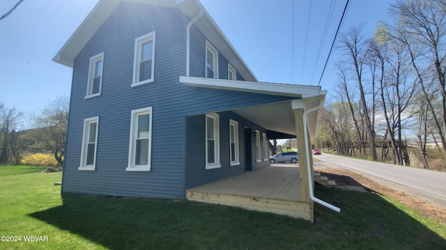 view of property exterior with a lawn and a porch