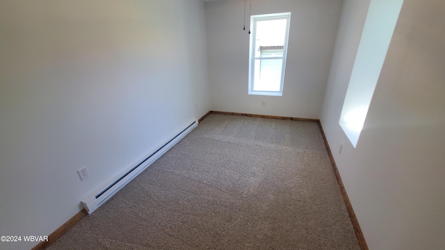 empty room featuring light carpet and a baseboard heating unit