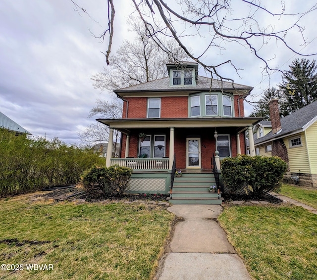 665 5th Ave, Williamsport, PA 17701 - american foursquare style home with brick siding, a front lawn, and covered porch