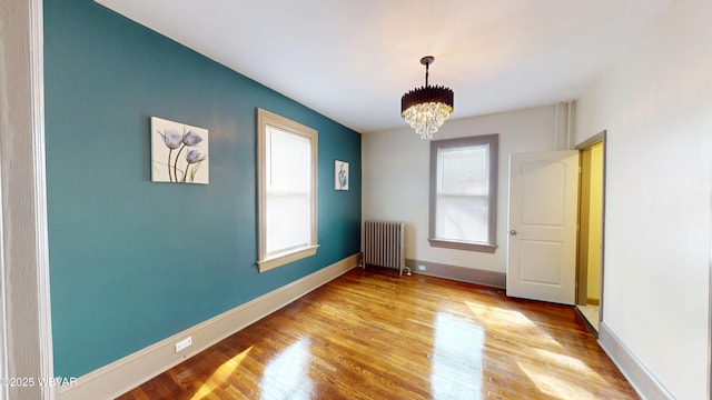665 5th Ave, Williamsport, PA 17701 - unfurnished room featuring radiator heating unit, light wood-type flooring, baseboards, and a chandelier