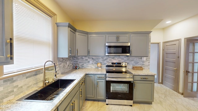 665 5th Ave, Williamsport, PA 17701 - kitchen featuring gray cabinets, appliances with stainless steel finishes, marble finish floor, a sink, and backsplash