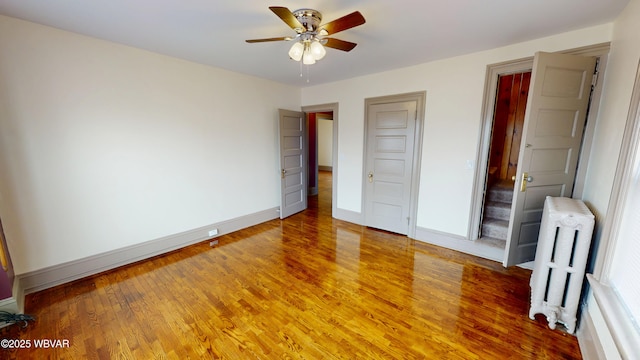 665 5th Ave, Williamsport, PA 17701 - unfurnished bedroom featuring radiator heating unit, light wood finished floors, baseboards, and a ceiling fan