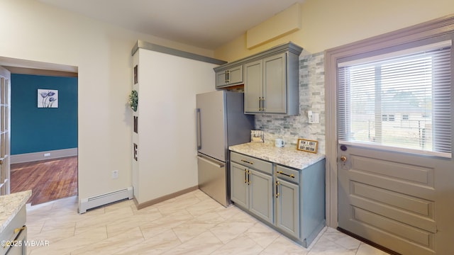 665 5th Ave, Williamsport, PA 17701 - kitchen featuring gray cabinets, decorative backsplash, freestanding refrigerator, and a baseboard heating unit