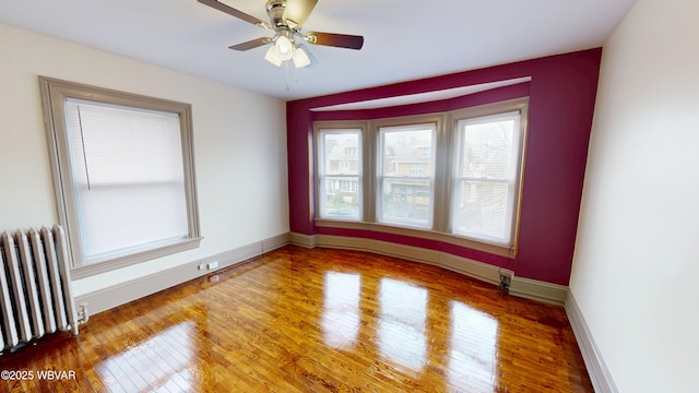665 5th Ave, Williamsport, PA 17701 - spare room featuring baseboards, a ceiling fan, radiator, and wood finished floors