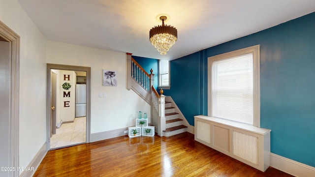 665 5th Ave, Williamsport, PA 17701 - interior space featuring baseboards, a notable chandelier, radiator, wood finished floors, and stairs