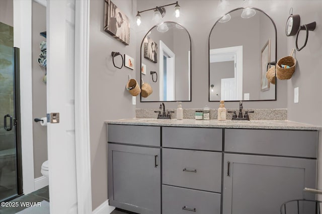 bathroom with toilet, vanity, and walk in shower