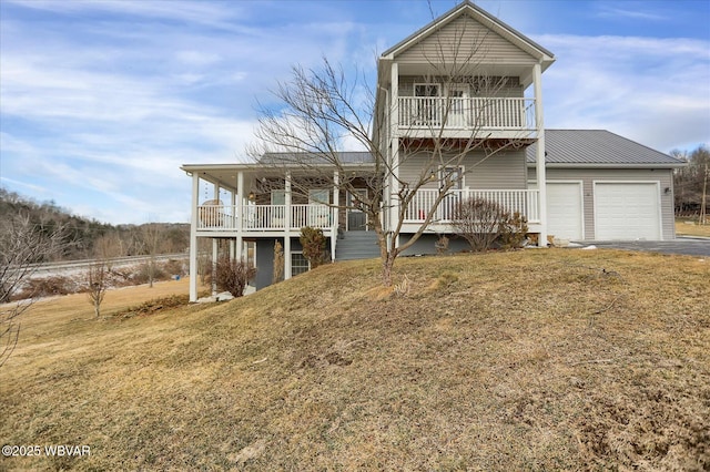 view of front facade featuring covered porch, a front yard, a garage, and a balcony