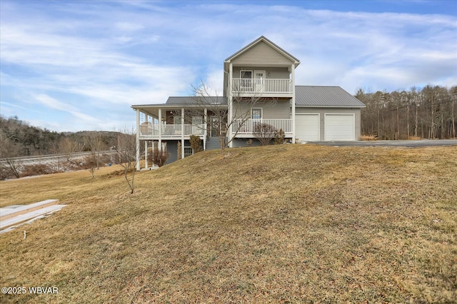 view of front facade featuring covered porch, a front yard, a garage, and a balcony