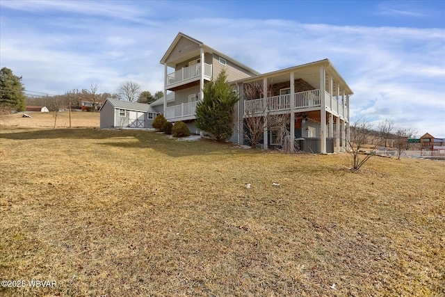 rear view of property featuring a balcony and a lawn