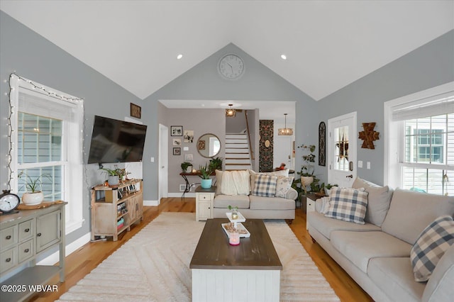 living room featuring light hardwood / wood-style floors and high vaulted ceiling