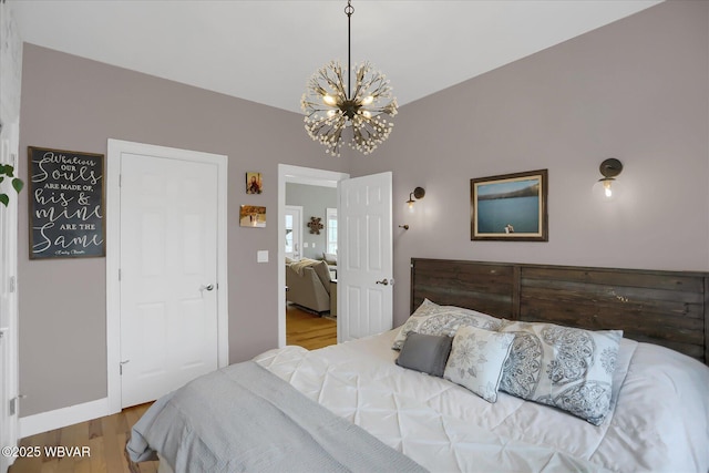 bedroom with hardwood / wood-style floors and a notable chandelier