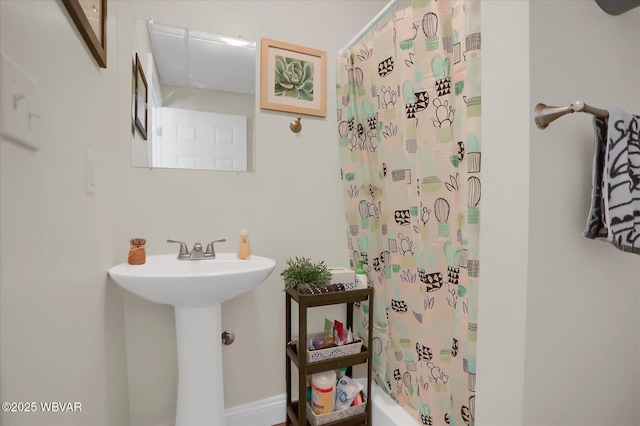 bathroom with shower / bath combination with curtain and sink